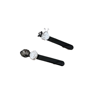 Set di fermagli minimalisti con cristalli neri e perle irregolari su sfondo bianco