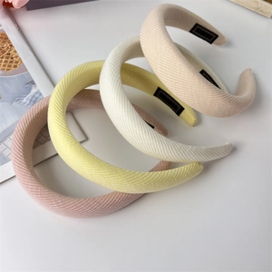 Detailed macro of four colorful padded fabric headbands showing thick twill weave texture