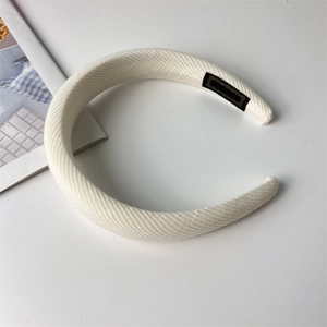 Detail view of a thick white sponge headband with high crown and twill knit texture