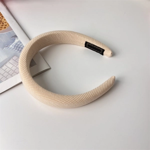 Detail of a beige padded sponge headband with twill texture fabric on white background