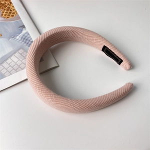 Close-up of pink padded sponge headband with shimmering knit fabric and inner label details