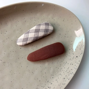 Detailed view of plaid and coffee fabric-covered water-drop snap hair clips set
