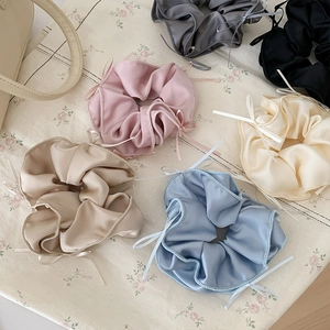 Elegant satin bow scrunchies set in various colors on vintage floral canvas background