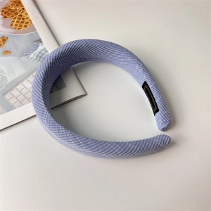 Detail view of the lilac sponge headband featuring a thick ribbed fabric texture and soft padding