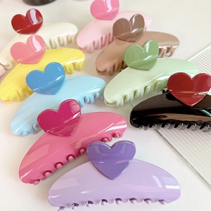 Flat lay of colorful 13cm oversized heart hair claws in eleven vibrant gloss finishes