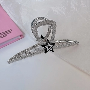 Détail macro d'une pince à cheveux étoile argentée avec finition mate et strass