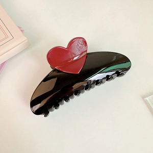 Detail of the 13cm oversized black hair claw clip featuring a deep red heart accent piece