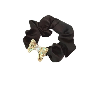 Elegant black satin scrunchie with a gold metal bow and sparkling crystal center