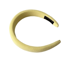 Puffy light yellow padded headband with textured knit fabric and high top design