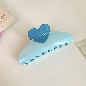Detail of 13cm light blue heart claw clip made of polished resin with deep blue accents