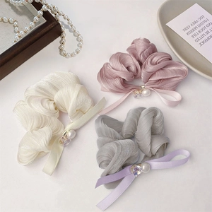 Elegant pearl bow scrunchies set in cream, lavender, and grey with crystal charms