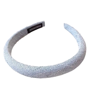 Elegant light blue padded headband with woven fabric texture and handmade label design