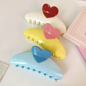 Three oversized 13cm hair claws with heart patterns in cream, blue, and yellow colors
