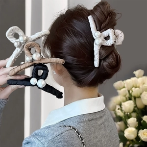Dettaglio di grandi fermagli per capelli con rivestimento in tessuto e doppie perle