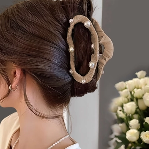 Détail de la pince à cheveux nuage avec tissu plissé et perles blanches sur cheveux