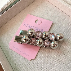 Ensemble de pinces à cheveux argentées avec cristaux roses et perles sur carte rose