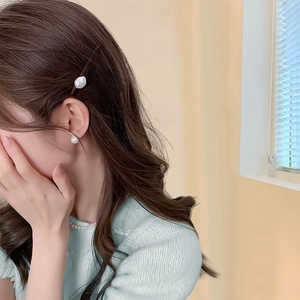 Détail d'une pince à cheveux élégante en perles baroques et parure de bijoux sur un modèle