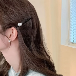 Pince à cheveux noire minimaliste avec perle baroque portée par un mannequin