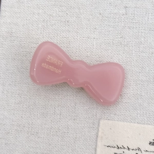 Nahaufnahme der handgefertigten rosa Haarklammer aus Acetat mit Logo-Detail