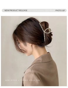 Dettaglio di una molletta per capelli in metallo dorato con cristalli sullo chignon