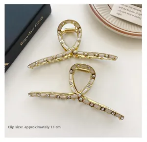 Dettaglio di fermagli per capelli in metallo dorato da 11 cm con perle e strass
