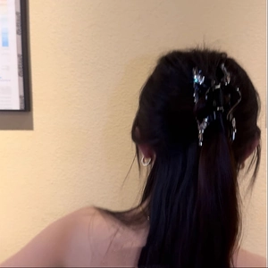 Rear view of model wearing a black butterfly hair claw clip with sparkling rhinestones