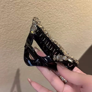 Close-up of sparkling rhinestones on the glossy black hair claw clip for women