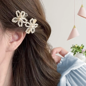 Gros plan de pinces à cheveux fleurs perlées portées par un mannequin en intérieur