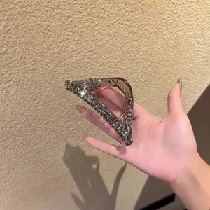 Detailed shot of sparkling triangle hair claw clip with rhinestones and champagne gold base