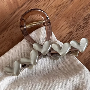Détail de la pince à cheveux coréenne avec corps transparent et cinq décorations de cœur