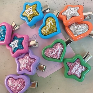 Detailed view of colorful glitter Y2K star and heart hair clips with Lucky Star text