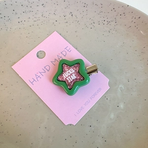 Macro detail of Y2K star hair clip with pink glitter and Lucky Star text on card