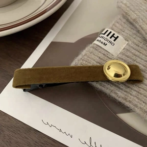 Detailed close-up of velvet olive green hair clip with retro golden metal buckle ornament