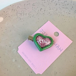 Y2K dopamine heart-shaped hair clip with pink glitter and Lucky text in green frame