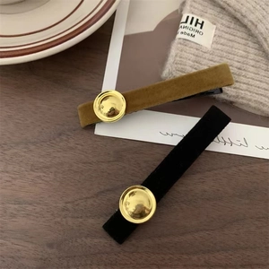 Detail of elegant velvet hair clips in olive brown and black with gold decorative buckles
