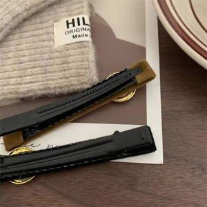 Brown and black velvet hair clips set with gold metal details and duckbill base