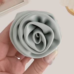 Close-up of mint green satin rose scrunchie featuring premium matte silk texture details