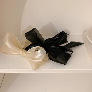Detail of chiffon bow banana clips in black and cream white with sheer organza texture