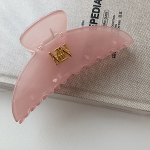 Pinza per capelli rosa gelatina con logo in metallo dorato e finitura in resina premium