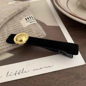 Elegant black velvet hair clip with a vintage gold circular button for women's hairstyle