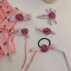 Detail von handgefertigten rosa Rosen-Haarklammern mit eleganten fließenden Quasten
