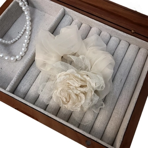 Chouchou élégant rose en organza crème présenté dans un coffret à bijoux en bois