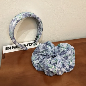 Detail of floral scrunchie and padded headband set with handmade label on wood surface