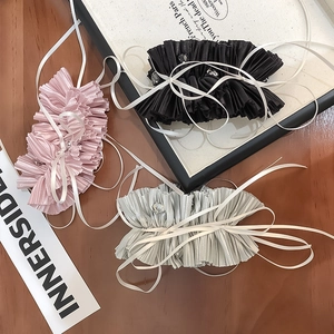 Close-up of pleated satin bow hair ties with heart gemstone accents in pink, black and silver