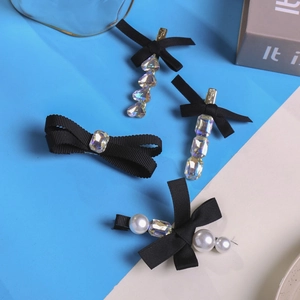 Detailopname van een 4-delige set zwarte haarspelden met parels en strass steentjes