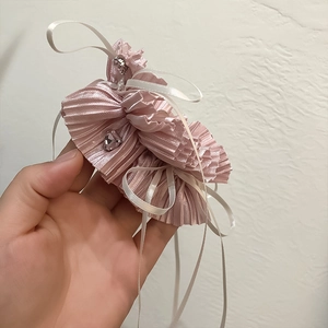 Detail of pink pleated hair tie with heart charms and white silk ribbons for women