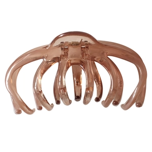 Detailed view of an octopus-shaped hair claw clip in amber translucent resin with metal spring