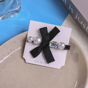 Macro-detail van strass strik haarclip met parels op een decoratief keramisch dienblad