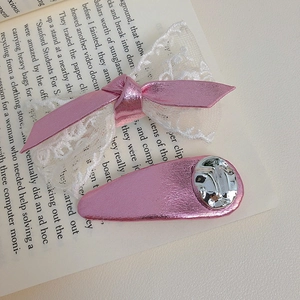 Rosa Haarschleife und Tropfen-Haarspange mit Spitze und Metallic-Finish auf Buchseiten