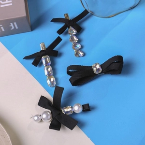 Elegante set van 4 zwarte strik haarspelden met parels en strass op een blauwe basis